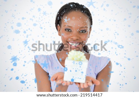 Close up of woman holding a present against a white background against snow falling