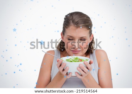 Composite image of woman smelling a salad against snow falling