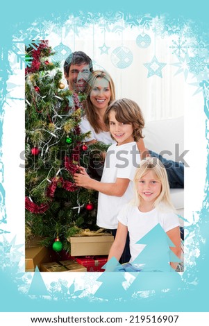 Portrait of a happy family decorating a Christmas tree against christmas frame