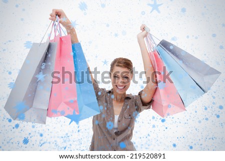 Woman raising her shopping bags against snow falling