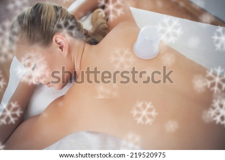 Pretty blonde with vacuum cup on her back against snowflakes