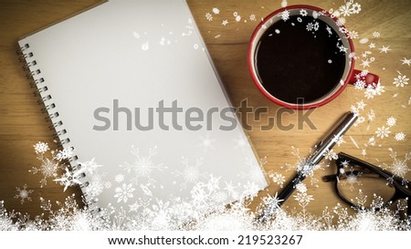 Snow against overhead of notepad and pen and coffee