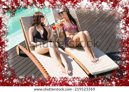 Women holding drinks by swimming pool against snow