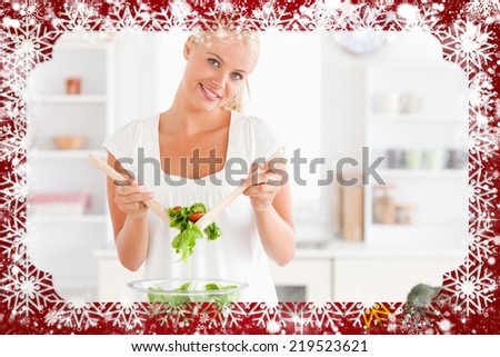 Composite image of cute woman mixing a salad against snow