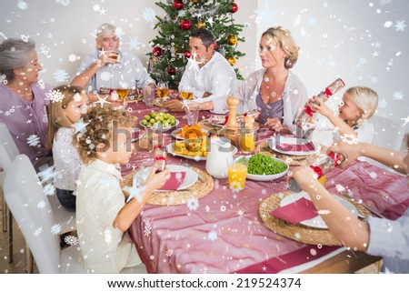 Composite image of Family having christmas dinner against snow
