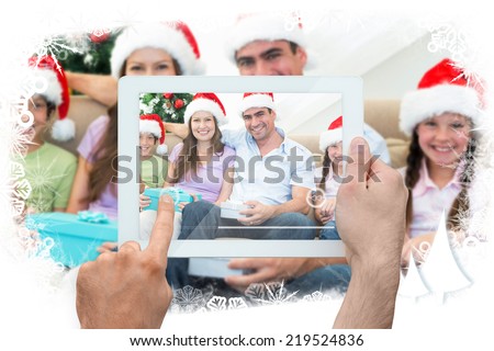 Composite image of hand holding tablet pc against frost frame