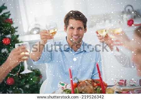 Composite image of Family toasting at christmas dinner against snow falling