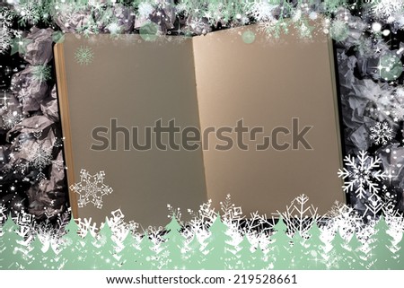 Composite image of snow frame against open blank notepad on paper