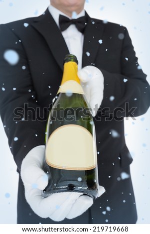 Composite image of open bottle of champagne against snow falling