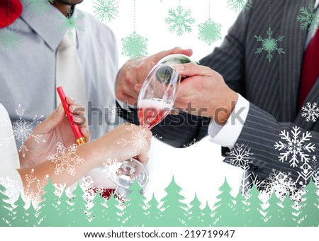 Close up of two colleague drinking champagne to celebrate christmas against snowflakes and fir trees in green