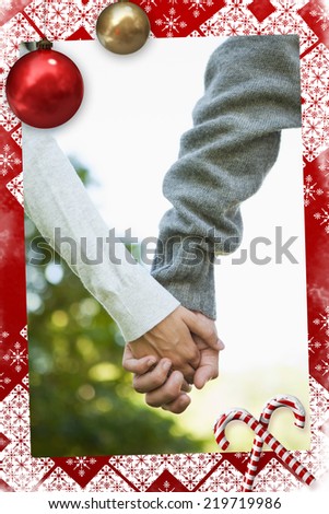 Cute couple holding hands in the park against christmas themed page