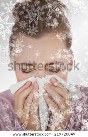 Composite image of woman blowing nose against snowflakes on silver