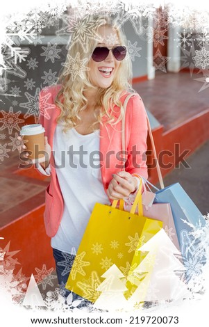 Pretty blonde holding shopping bags and coffee cup against christmas frame