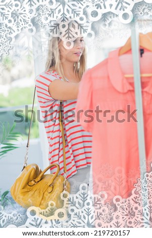 Woman standing and looking at clothes against snowflakes on silver