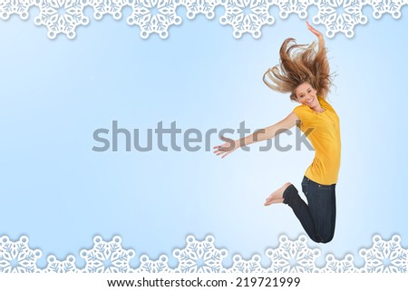 Pretty young woman jumping for joy against snowflake frame