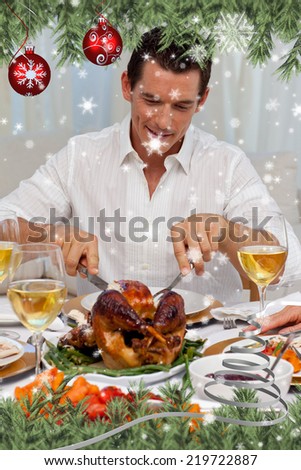Attractive man eating turkey in Christmas dinner against snow falling