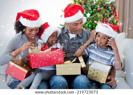 Happy family playing with Christmas presents against snow Happy family playing with Christmas presents against snow