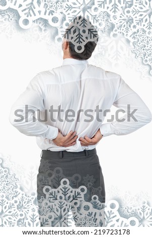 Portrait of the painful back of a young businessman against snowflakes on silver