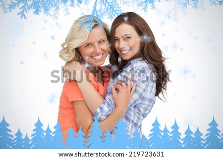 Two friends taking each other in arms against frost and fir trees in blue