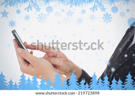 Detail view of woman using smart phone against snow flake frame in blue