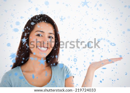 Portrait of a gorgeous woman showing a copy space while standing against snow falling