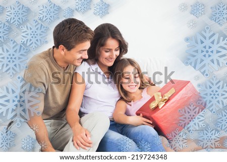 Parents offering a gift against snowflake frame
