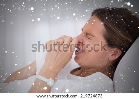 Composite image of side view of sneezing woman against snow