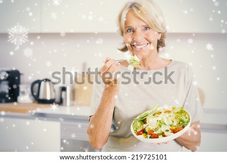 Composite image of smiling woman eating salad against snow falling