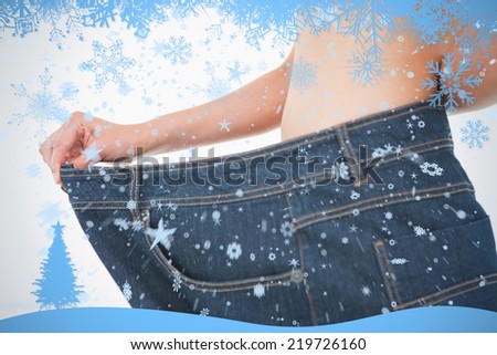 Close up of a woman belly in too big pants against snow flake frame in blue