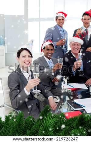 Manager and his team with novelty Christmas hat toasting at a party against snow falling