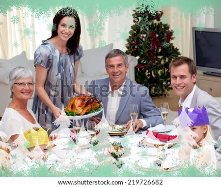 Family celebrating Christmas dinner with turkey against green snowflake design