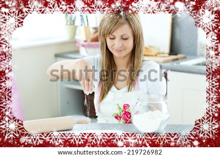 Portrait of a cute woman preparing a cake in the kitchen against snow