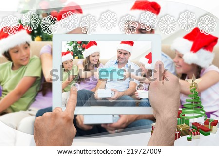 Hand holding tablet pc against snowflake frame