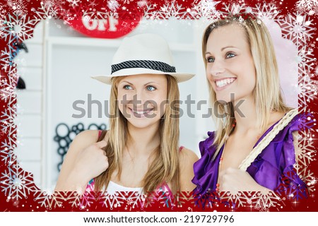 Confident women choosing clothes together against snow