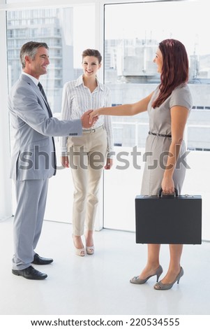 Businessman shaking co-workers hand while at work