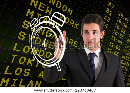 Businessman standing and pointing to a white clock against black airport departures board with yellow text