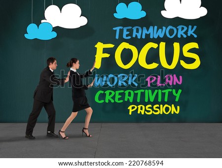 Businessman standing andComposite image of business team standing and pushing against buzz words in room