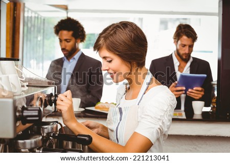 Pretty barista making cup of coffee at the coffee shop