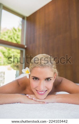 Close up portrait of a beautiful young woman lying on massage table at spa center