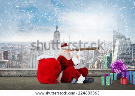 Santa looking through telescope against balcony overlooking city