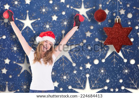 Festive blonde with boxing gloves against snowflake wallpaper pattern