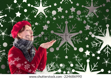 Woman blowing kiss from hands against snowflake wallpaper pattern