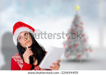 Woman thinking what to write against blurry christmas tree in room