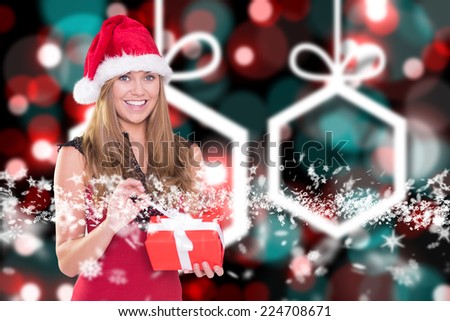 Festive blonde opening a gift against blurred christmas background