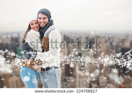 Young winter couple against city skyline