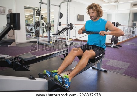 Full length of a handsome young man using resistance band in gym