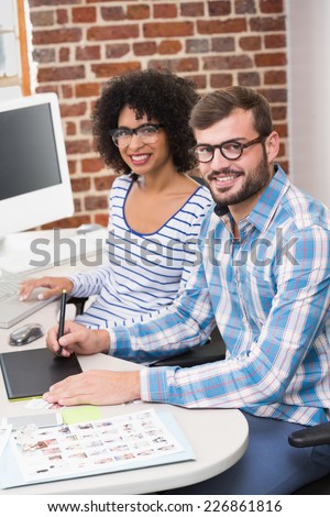 Portrait of smiling photo editors using digitizer in the office