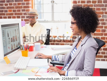 Side view of female photo editor using computer in the office