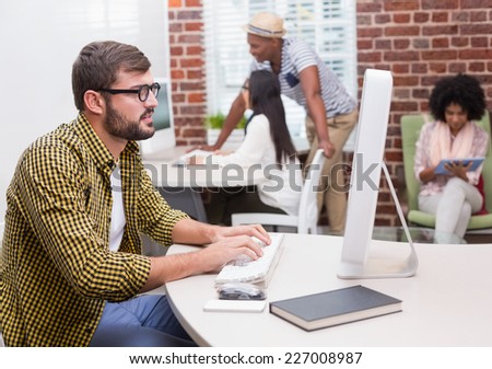 Concentrated casual young man using computer in the office