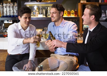 Handsome friends having a drink together at the bar